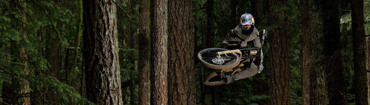 Brandon Semenuk, Team NORTH Athlete, jumps his mountain bike on a forest trail