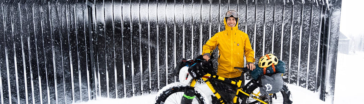 Chris Burkard, Team NORTH, standing in the arctic ice with his mountain bike