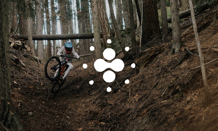 Photo of a mountain biker in action. There is an icon on top of the image.