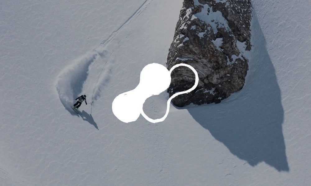 Photo of a skier in action heading down a steep slope. There is an icon on top of the image.